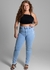 Modelo usando calça jeans plus size Sawary, com um top preto e sandálias, destacando a peça em um fundo neutro.