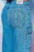 Calça feminina wide leg em tecido jeans azul, com detalhes de bolso e etiqueta na cintura.