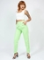 Modelo usando calça mom verde com pregas, combinando com top branco e sandália de salto.