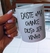 Caneca branca personalizada com a frase "Existe uma chance disso ser vinho" sendo segurada por uma mão com unhas pintadas de lilás