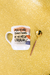 Caneca personalizada branca com a frase "Mas eu não tenho 1 minuto de paz nesse caralho", ao lado de uma colher dourada, sobre um fundo dourado brilhante.