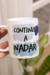 Caneca branca com texto "Continue a nadar" em letras pretas sobre fundo de pinceladas em tons de azul e lilás