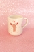 Caneca personalizada com desenho de um punho cerrado e corações, sobre fundo rosa brilhante.